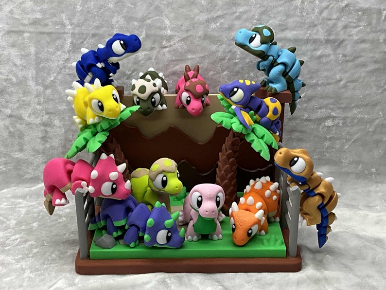 May include: A collection of colorful dinosaur figurines, including blue, yellow, pink, and orange, arranged on a miniature diorama. The scene features a brown structure with green foliage, creating a playful prehistoric theme.