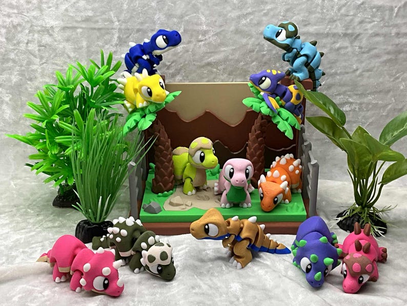 May include: A collection of colorful, handcrafted dinosaur figurines. The scene includes various species in shades of pink, green, blue, yellow, and orange, set against a backdrop of a miniature landscape with trees and foliage. These figurines are likely made of clay.