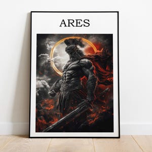 Puede incluir: Impresión artística enmarcada que presenta a un guerrero musculoso con una espada, sobre un fondo de fuego y nubes. La palabra "ARES" está impresa en negro en la parte superior. La obra de arte está en un marco negro y se encuentra sobre un suelo de madera.