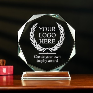 May include: A clear glass octagonal trophy award with a laurel wreath design and the text "YOUR LOGO HERE" and "Create your own trophy award".