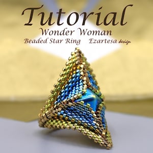 Könnte beinhalten: Ein dreieckiger Perlenring mit einem sternförmigen Zentrum. Der Ring ist aus blauen, goldenen und grünen Perlen gefertigt. Der Ring ist mit "Wonder Woman Beaded Star Ring Ezaretes Design" betitelt.