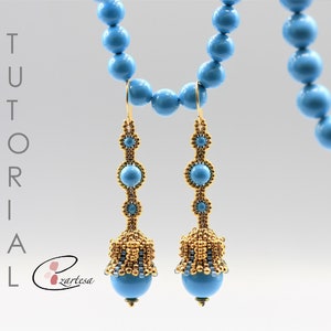 Può includere: Un paio di orecchini con perline turchesi e dorate con un design a forma di campana. Gli orecchini sono appesi a una collana di perline turchesi.