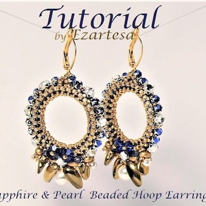 Pode incluir: Um par de brincos de argola dourados com um pingente de safira e pérola. Os brincos são feitos com pequenas contas azuis, brancas e douradas. Os brincos são chamados de "Brincos de argola com contas de safira e pérola".