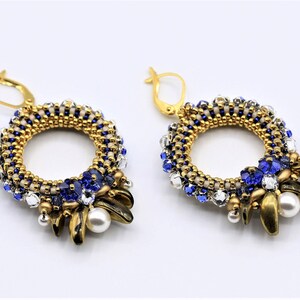 May include: Gold and blue beaded earrings with a circular design and pearl accents.