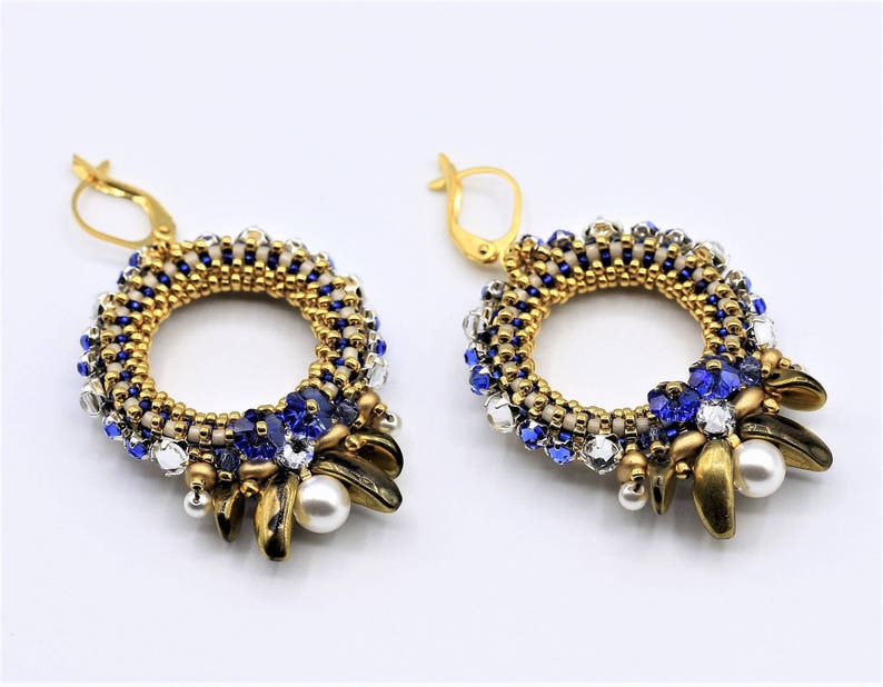 May include: Gold and blue beaded earrings with a circular design and pearl accents.