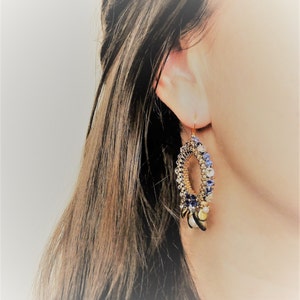 May include: Gold hoop earrings with blue and white beads and gold accents.