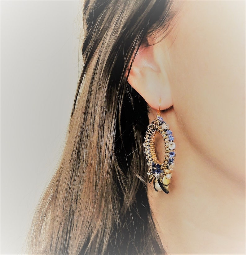 May include: Gold hoop earrings with blue and white beads and gold accents.