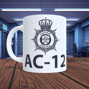 May include: White ceramic mug with the Central Police emblem in black, a crown, and the text "AC-12". The mug is displayed against a blurred backdrop of a police station interior, with a wooden table in the foreground.