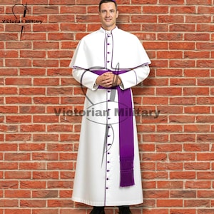 May include: A white robe with purple trim and accents, including a matching sash and buttons. The robe has a capelet and is worn by a person. The text "Victorian Military" is visible in the image.