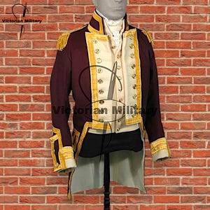 May include: A burgundy military jacket with gold trim and epaulets. The jacket features a cream-coloured vest with gold buttons. The text "Victorian Military" is visible. The jacket is displayed on a mannequin against a brick wall.