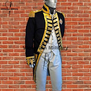 May include: A dark navy blue military-style tailcoat featuring gold braided trim, gold-tone buttons, and gold fringe epaulets, worn over a white waistcoat and light gray breeches. The jacket displays a prominent gold star emblem on the chest.