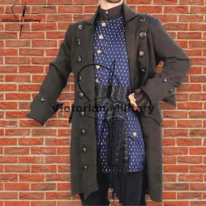 Può includere: Un cappotto militare vittoriano grigio scuro con grandi bottoni neri e maniche lunghe. Il cappotto è sovrapposto a una camicia blu fantasia e a un gilet decorativo. Il testo "Victorian Military" è visibile.