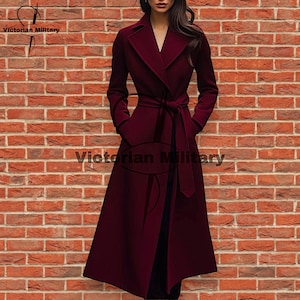 May include: A long, burgundy coat with a tie belt and pockets. The coat has a wide lapel and is knee-length. The text "Victorian Military" is printed on the coat. The coat is displayed in front of a brick wall.