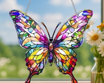 May include: A colorful stained-glass butterfly suncatcher with a chain for hanging. The butterfly's wings are a mosaic of vibrant colors including purple, yellow, green, and blue. The butterfly is hanging in front of a window with a blue sky background.