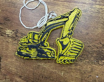 May include: A yellow and black excavator-shaped ornament with a white string and metal ring for hanging. The excavator features a detailed design with black outlines and accents. The ornament is likely made of a durable material and is suitable for construction-themed decor.