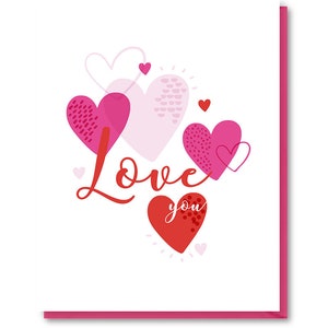 May include: A Valentine's Day card with a white background and pink and red hearts. The card says "Love you" in red cursive lettering.