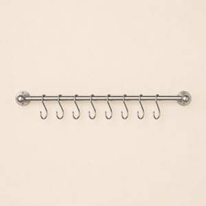May include: A brushed silver metal wall-mounted rail featuring a horizontal rod with rounded end caps and eight removable S-shaped hooks hanging from the bar. The hardware is designed for mounting to a flat surface with circular plates.