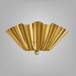 May include: A gold-colored metal wall sconce featuring a wide, semi-circular, pleated fan design with a smooth, reflective finish. A small, spherical brass knob is centered at the bottom point of the fixture. The text retrobrasslightco is visible.