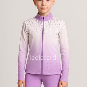 Könnte beinhalten: Ein helllila-weißes Sportjacken- und Hosen-Set. Die Jacke hat einen hohen Kragen und einen durchgehenden Reißverschluss. Das Set ist mit kleinen, glitzernden Akzenten verziert. Der Markenname "Iceletard" ist auf der Jacke aufgedruckt.