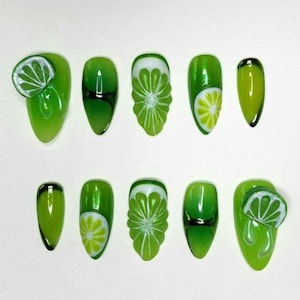 Peut inclure: Dix faux ongles verts avec un motif de tranche de citron vert. Certains ongles présentent une tranche de citron vert en 3D, tandis que d'autres ont un motif de citron vert peint. Les ongles sont de forme ovale et ont une finition brillante.