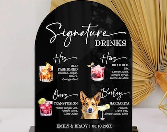 May include: An arched black acrylic sign titled Signature Drinks featuring illustrations of four cocktails and a dog. The text lists His Old Fashioned, Hers Bramble, Ours Transfusion, and Bailey Margarita, with the names Emily & Brady and 05.10.20XX.