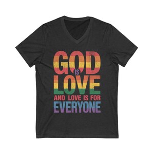 May include: Dark gray V-neck t-shirt with the text "GOD IS LOVE AND LOVE IS FOR EVERYONE" in rainbow colors. The text is in a bold, distressed font. The shirt is made of a soft material.