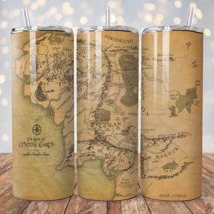Puede incluir: Tres vasos de acero inoxidable con un mapa de la Tierra Media de El Señor de los Anillos. El mapa está en tonos marrones y verdes con texto que dice "El Señor de los Anillos, El Mapa de la Tierra Media, Forodwaith, Rohan, Mordor, Cerca de Harad".