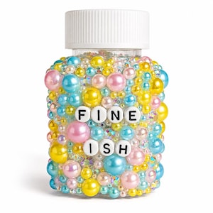 May include: A clear plastic jar with a white screw-top lid, densely covered in a mix of multicoloured pearls and iridescent rhinestones. The words FINE ISH are spelled out in white square beads with black lettering centred on the front surface.