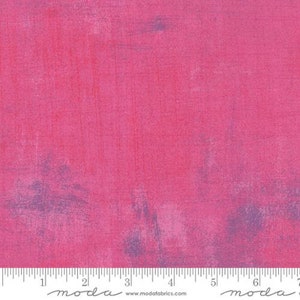 Może przedstawiać: Żywy różowy materiał o teksturowanym, malarskim efekcie. Tkanina charakteryzuje się subtelnymi zmianami koloru i faktury, z nutą fioletu i bieli. Na dole obrazu znajduje się linijka z pomiarami w calach.