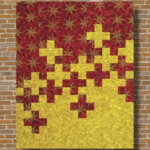 Puede incluir: Un edredón con un diseño de patchwork. La mitad superior es de color rojo oscuro con detalles dorados, y la mitad inferior es amarilla. El edredón presenta un patrón de signos más. El texto "Add it Up" está en la parte superior.