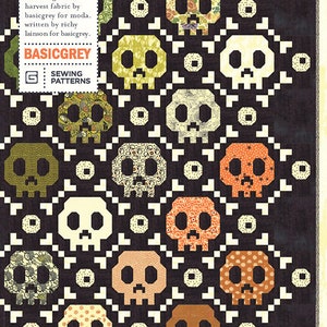 May include: A quilt pattern featuring a repeating skull design in various colors, including green, orange, and brown, set against a dark background. The quilt pattern is titled "Bone & Chain" and includes the text "PAT014" and "BASICGREY".