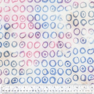 May include: Fabric with a repeating pattern of colorful, irregular circles. The circles are in shades of blue, purple, and pink, set against a white background. A ruler is at the bottom, showing measurements in inches.