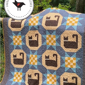 May include: A blue, brown, and yellow quilt with a cat pattern. The quilt features repeating cat silhouettes within octagons, surrounded by star and checkerboard patterns. The quilt measures 58" x 82" and 46" x 46". The text "MIDNIGHT PROWL" is at the top.
