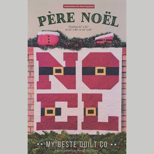 May include: A Christmas-themed quilt pattern with the words "PÈRE NOËL" and "NOEL" in red, black, and gold. The quilt finishes 42" x 42" or 22" x 80" or 20" x 84". The pattern is by My Beste Quilt Co.