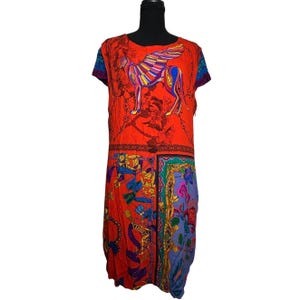 May include: A knee-length dress with a striking design. The dress has a red base with a colourful winged creature illustration. The lower section displays a mix of patterns, including floral and chain motifs, in shades of blue, green, and purple.