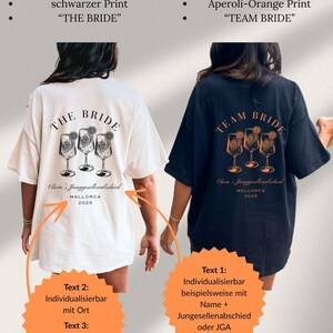 May include: White and black t-shirts with back prints for a bachelorette party. The white shirt says "THE BRIDE" with a cocktail graphic, and the black shirt says "TEAM BRIDE" with an orange cocktail graphic. Text on the shirts includes "Olivia's Junggesellenabschied MALLORCA 2025".