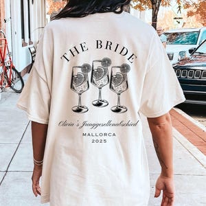 JGA T-Shirt The Bride & Team Bride – personalisiert mit Name Ort Jahr – Junggesellinnenabschied Braut Crew Party Shirt Weiß "THE BRIDE"