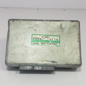 以下が含まれることがあります： 長方形の銀色の電子制御ユニットで、緑と白のラベルが付いています。 ラベルには「89545-76110」や「SUMITOMO ELECTRIC」などのテキストと数字が表示されています。 下部には灰色のコネクタが見えます。