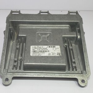 May include: A silver Mercedes-Benz electronic control unit. The unit is rectangular with vertical fins and a label with the text "A 206 153 06 79 MERCEDES-BENZ HW: A 001 446 02 40". It is designed for automotive use.