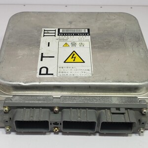 以下が含まれることがあります： 3つの灰色のコネクタが付いた銀色の電子制御ユニット（ECU）。ECUには日本語のテキストと警告記号が付いたラベルが付いています。長方形のユニットは角が丸く、ネジで固定されています。ラベルのテキストには「LOCK」という単語が含まれています。