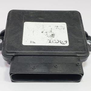 Puede incluir: Una unidad de control electrónico negra con forma rectangular y un conector grande. Una etiqueta blanca con texto y un logotipo de Audi está adherida a la parte superior. La unidad tiene pestañas de montaje a cada lado.