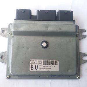 以下が含まれることがあります： シルバーカラーの日産エンジンコントロールユニット（ECU）で、上部に3つの黒いコネクタが付いています。ECUは長方形で、取り付けタブとテキストとバーコードのラベルが付いています。ラベルには「NISSAN」と「BU」の文字が含まれています。
