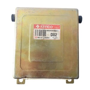 May include: A rectangular, gold-coloured electronic control unit (ECU) with a label that reads "KEFICO KOREA" and "D02". The ECU has two black connectors and mounting tabs. The label also includes a barcode and other identifying numbers.