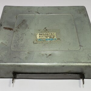 May include: A silver metal box with a label that reads "MD336151 E2T65876 M1T".