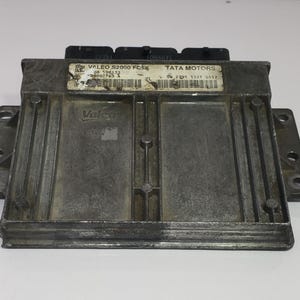 Könnte beinhalten: Ein rechteckiges, metallisch graues elektronisches Steuergerät (ECU) mit schwarzen Anschlüssen. Das Steuergerät trägt ein Etikett mit der Aufschrift "VALEO S2000 FC56" und "TATA MOTORS". Das Gerät hat Halterungen an jeder Seite.