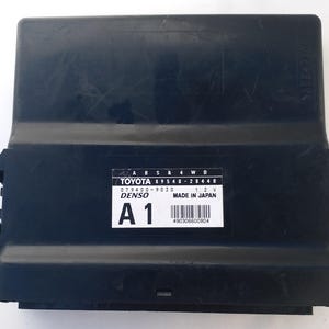 Op de afbeelding: Een zwart Toyota auto-onderdeel met een rechthoekige vorm. Het onderdeel heeft een label met de Toyota- en Denso-logo's, samen met tekst met "ABS & 4WD" en "MADE IN JAPAN". Het onderdeel is gemarkeerd met "A1".