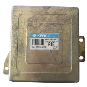 Puede incluir: Módulo informático automotriz rectangular de color metálico. El módulo tiene una etiqueta azul y blanca con la marca "KEFICO" y otra información impresa, incluido un código de barras y el texto "R1E".