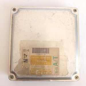 Può includere: Modulo di controllo motore Toyota argentato, rettangolare con angoli arrotondati. Un'etichetta mostra "ENGINE CONTROL", "TOYOTA" e "DENSO". Il coperchio è fissato da quattro viti. Misure non disponibili.