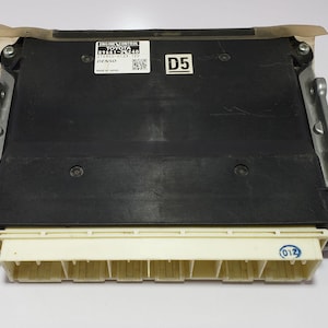 May include: Black engine control unit with a white label that reads "ENGINE CONTROL TOYOTA 89661-0T240 275800-0123 12V DENSO MADE IN JAPAN" and a black label that reads "D5".