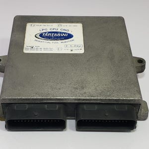 Può includere: Un'unità LPG CPU CNG color argento con connettori neri. L'unità ha un'etichetta che recita "TARTARINI" e "SEQUENTIAL FUEL INJECTION". L'unità è progettata per motori a 2-3-4 cilindri.